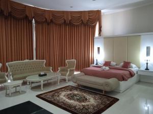 a bedroom with a bed and a living room at Aliante Malang in Malang