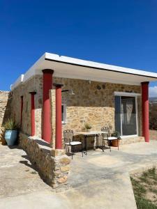 a stone building with a table and chairs outside at Studio Aphrodite in Afiartis