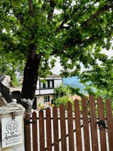a wooden fence with a tree in front of a house at ΤΟ ΑΡΧΟΝΤΙΚΟ in Kríkellon