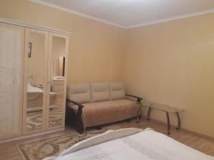 a living room with a couch and a mirror at Celebrity in Kamianets-Podilskyi