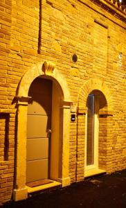 een bakstenen gebouw met twee bogen en een deur bij Bed Art Relaxing Suite - Appartamento con Sauna Happiness Suite Gallery in San Benedetto del Tronto
