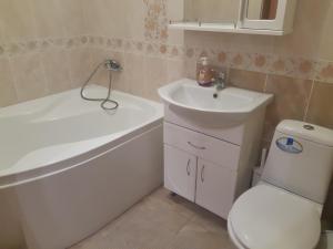 a bathroom with a toilet and a sink and a tub at Celebrity in Kamianets-Podilskyi
