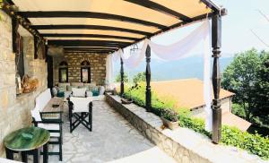 un patio al aire libre con pérgola, mesa y sillas en ΤΟ ΑΡΧΟΝΤΙΚΟ, en Kríkellon