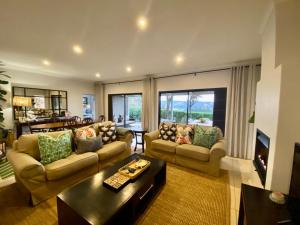 Una sala de estar con dos sofás y una mesa. en WildCroft 20, en Balgowan