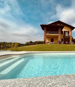 a house with a swimming pool in front of a house at Ca' Colomba in San Damiano dʼAsti