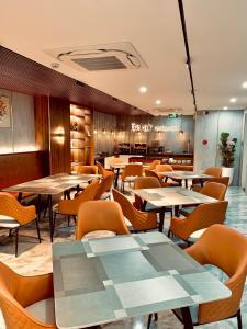 um restaurante com mesas e cadeiras num quarto em Bel-Air Hotel em Quy Nhon