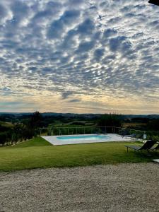 une grande piscine sous un ciel nuageux dans l'établissement Ca' Colomba, à San Damiano dʼAsti