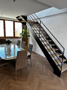 a dining room with a glass table and a staircase at Luxury PENTHOUSE at the Historical Centre with free parking in Bratislava