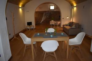 een woonkamer met een tafel en witte stoelen bij Casa Selinunte in Palermo