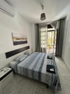 Un dormitorio con una cama grande y una ventana en The Spot Central Hostel, en Sevilla