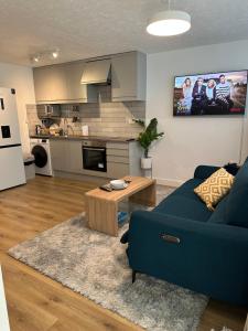 sala de estar con sofá azul y mesa en Dartford Luxurious House with Parking - Netflix - Wi-Fi, en Kent