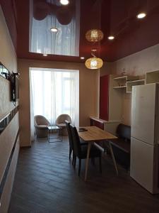 eine kleine Küche mit einem Tisch und einem Kühlschrank in der Unterkunft Luxury for Business & Pleasure Royal in Dnipro