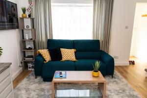 a living room with a blue couch and a coffee table at Dartford Luxurious House with Parking - Netflix - Wi-Fi in Kent