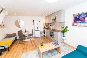 a living room with a bed a table and a kitchen at Dartford Luxurious House with Parking - Netflix - Wi-Fi in Kent +26 photos