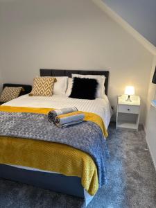 1 dormitorio con 1 cama grande con manta amarilla en Dartford Luxurious House with Parking - Netflix - Wi-Fi en Kent
