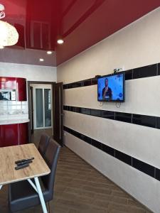 ein Wartezimmer mit einem Tisch und einem TV an der Wand in der Unterkunft Luxury for Business & Pleasure Royal in Dnipro