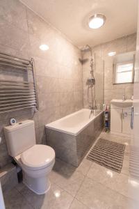 e bagno con servizi igienici, vasca e lavandino. di Dartford Luxurious House with Parking - Netflix - Wi-Fi a Kent