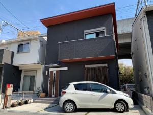 um carro branco estacionado em frente a uma casa em Guesthouse Kaede Annex em Nara