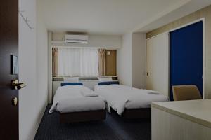 una camera d'albergo con due letti e una cucina di Folio Sakura Shinsaibashi Osaka by Banyan Group ad Osaka