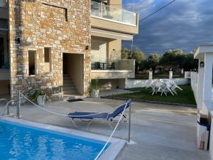 a house with a swimming pool in front of a house at Green Memories in Skala Sotiros