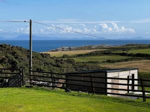 a fence on a hill with the ocean in the background at Sea View Fields Trearddur in Holyhead
