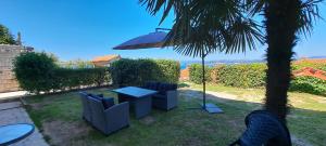 a patio with a table and chairs and an umbrella at Apartma Rian in Koper