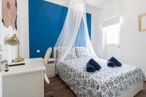 een slaapkamer met een bed en een blauwe muur bij La Bussola in Las Palmas de Gran Canaria