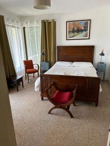 1 dormitorio con 1 cama y 1 silla roja en Modern 4 Bedroom House Ring of Kerry -Killarney en Killarney