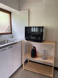a kitchen with a microwave sitting on a shelf at 谷地頭温泉近く！ピアノのある一軒家（English OK） in Hakodate