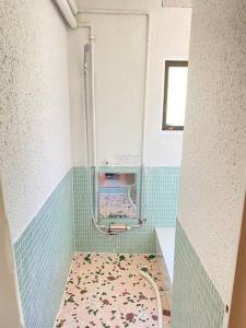 a bathroom with a shower with a tile floor at 谷地頭温泉近く！ピアノのある一軒家（English OK） in Hakodate