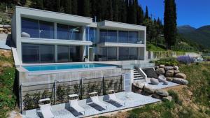 a house with a swimming pool and some chairs at Infinity Villa Salò in Salò