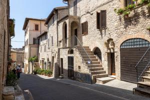 ein Steingebäude mit einer Treppe an der Straßenseite in der Unterkunft [Loft Rustico] in Centro Storico in Assisi