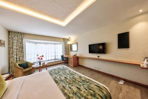 a hotel room with a bed and a flat screen tv at The Central Park in Pune