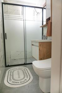 een badkamer met een toilet en een glazen douche bij Platine Apartments in Istanbul