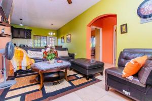 a living room with a couch and a table at J&R Sunshine Retreat in Spanish Town