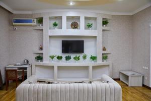a living room with a white couch and a tv at Elite Art Hotel in Tashkent