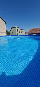 una gran piscina azul con un edificio en el fondo en Dinara View Apartment-Knin en Knin