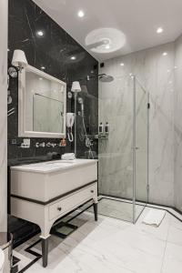 y baño con lavabo y ducha. en Hotel Balkan en Belgrado
