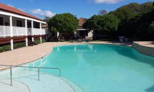 a large blue swimming pool next to a house at 7 @ The Dunes in Plettenberg Bay