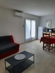 een woonkamer met een bank en een tafel bij Location Eygalieres "le Juliette" in Eygalières