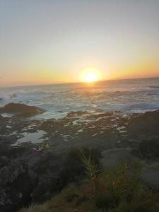 a sunset over the ocean with the sun setting at Casa Dos Mosteiros in Mosteiros