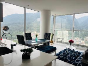 a living room with a table and chairs and a large window at Apartamento piso 41 VIP hermoso en Bogotá in Bogotá