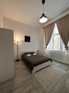 Un dormitorio con una cama y una ventana grande. en Dolce Vita House, en Budapest
