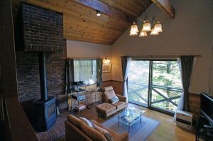 a living room with a fireplace and a brick wall at HARUNA SKY Panoramic view of Nasu,private space surrounded by fir trees,relaxing stone bath,watching movies on a 120inch big screen in Nasu