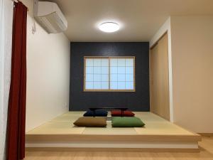 ein Zimmer mit einer Bank mit Kissen darauf in der Unterkunft Guesthouse Kaede Annex in Nara