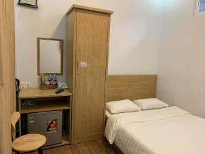Dormitorio pequeño con cama y espejo en Dang Nguyen Guesthouse, en Da Lat