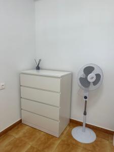 una cómoda blanca con ventilador junto a una cómoda en Las Americas Tenerife, en Arona
