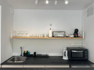 a kitchen with a sink and a microwave on a counter at Las Americas Tenerife in Arona