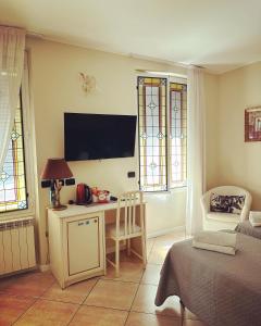 a room with a desk with a tv and windows at Camere Chicca in Sanremo