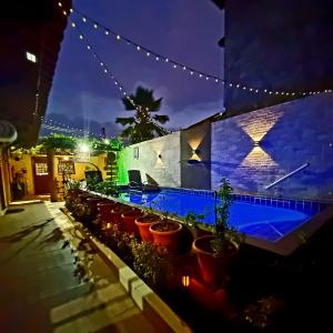 a group of potted plants in front of a building at night at Pousada Flats Três Milagres-Flats Capitão Gabriel e Carolinda - Studios Ceci, Abelhinha e Buguinho- Com Café opcional in São Miguel dos Milagres